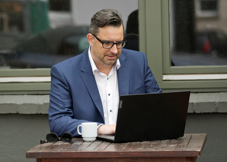 Businessfotos Mann mit Laptop am Tisch Outdoor