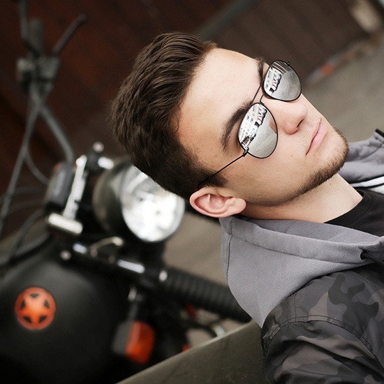 Teenager junger Mann mit Spiegelbrille vor Motorrad Portraitfotos