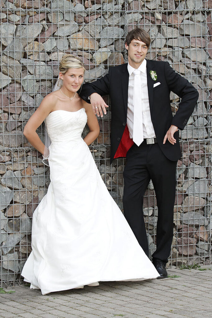 Hochzeitsfotografin Hochzeitpaar kirchliche Hochzeit an einer Steinwand