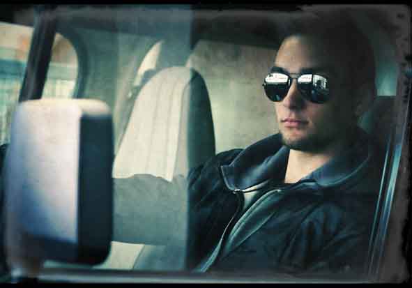 Portraitfoto Mann im Auto mit verspiegelter Brille